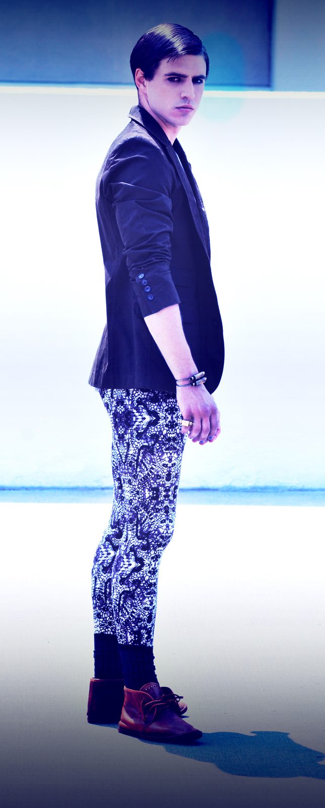 Male model in patterned leggings, a dark blazer and brown shoes