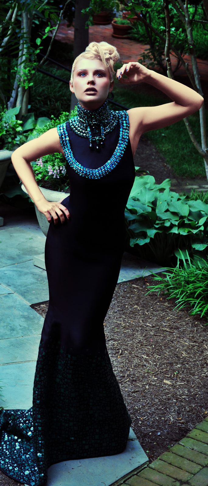Model with a sculpted platinum updo in a black column gown with a turquoise beaded collar