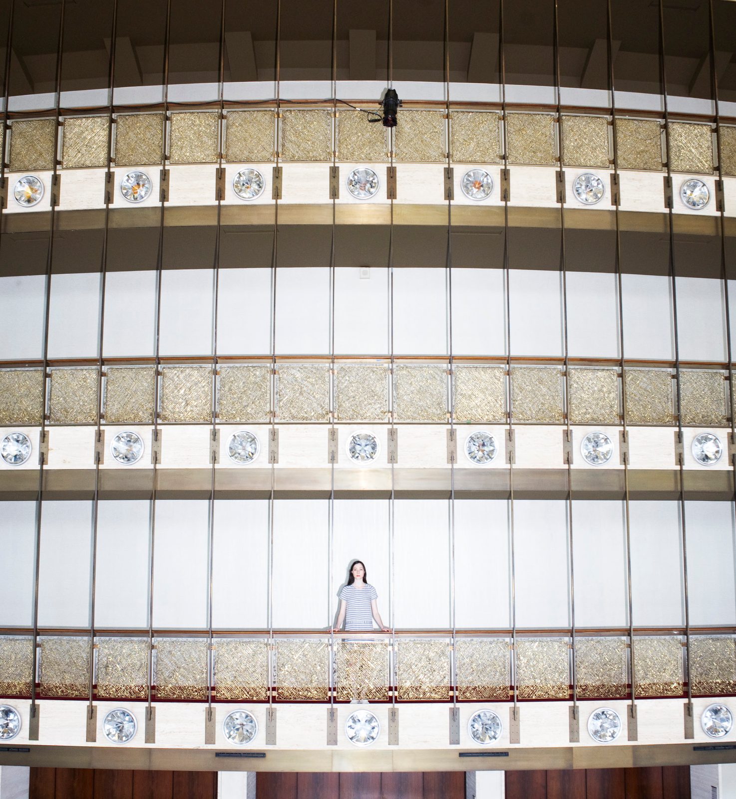 Ellen Bar standing small at the center of the tiered gold balconies of a Lincoln Center theater