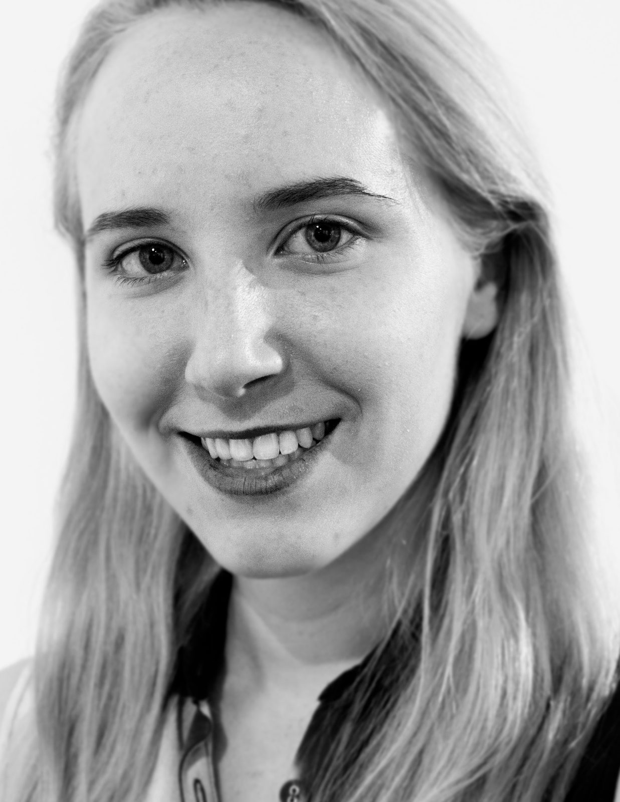 Black and white portrait of designer Sarah Richards smiling, with long straight blond hair